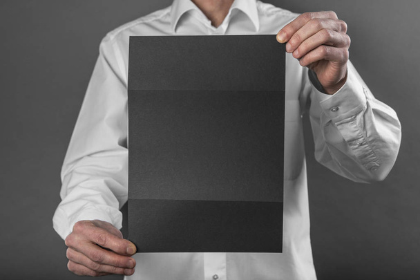 A man holding black booklet - Фото, зображення
