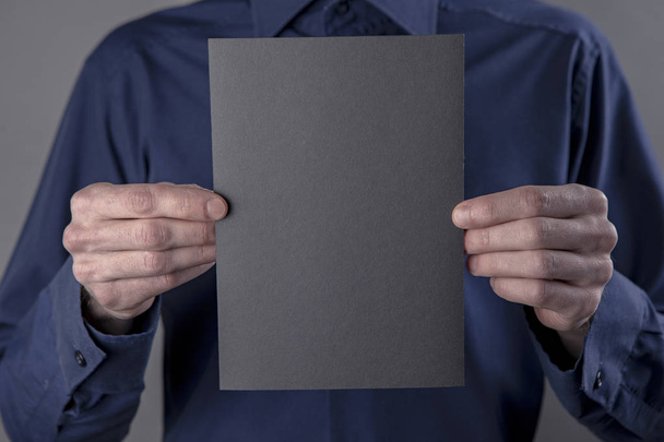 A man holding black booklet - Zdjęcie, obraz