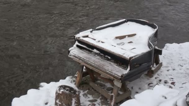 Złamane opuszczonych snowy fortepian instrument muzyczny, w pobliżu rzeki zima - Materiał filmowy, wideo