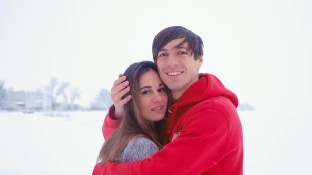 Šťastný mladík objímá svou přítelkyni. Emocionální pár v lásce objímání v zimě na sněhu pozadí. Setkání po dlouhé odloučení. - Záběry, video
