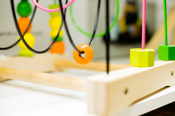 Wire bead maze standing on a table. Kid activities.Colorful Educational Toy.Wooden Wire Maze Educational Game Toys - Fotografie, Obrázek