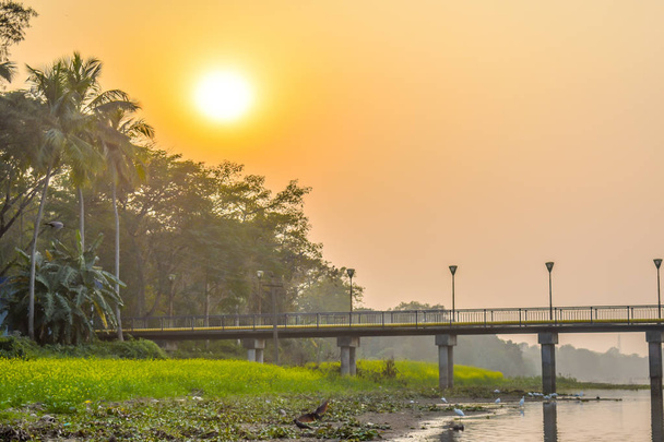 Vue paysage d'un petit village près de la rive de la rivière "Kumari", Mukutmanipur, Bankura, Bengale occidental. Un beau paysage de l'Inde rurale au coucher du soleil avec ciel clair et réflexion sur l'eau de la rivière
 - Photo, image