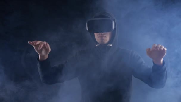 男は暗い煙のような背景で Vr のヘッドセットを使用しての経験を得るします。拡張現実感のデバイスが仮想空間を作成します。. - 映像、動画