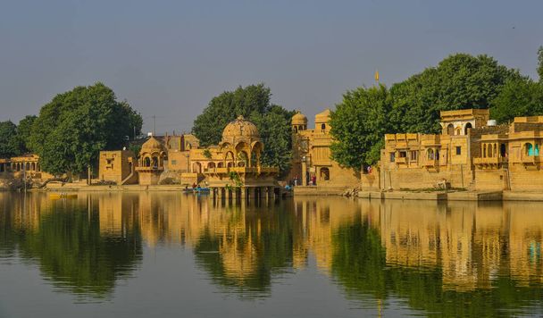 Gadsisar järvi antiikin hindujen temppeleitä aurinkoisena päivänä Jaisalmer, Intia
. - Valokuva, kuva