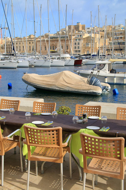 Photo taken on the island of Malta. The picture shows the breakfast table standing on the marina. - Photo, Image