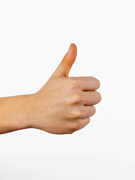 Szoros férfi kéz mutató hüvelykujj fel jel fehér háttér - Fotó, kép