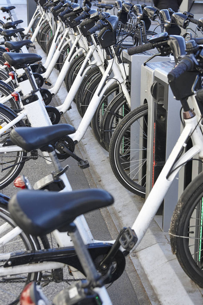 Carga de bicicletas urbanas de batería eléctrica en la ciudad. Transporte ecológico
 - Foto, imagen