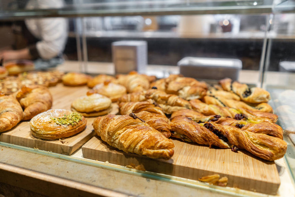 Croissant, puffs and other pastries. Showcase desserts in an Italian cafe or trattoria. Variety of cakes on display. - Photo, Image