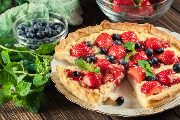 Tart with curd cheese, strawberries and blueberries decorated with mint leaves - Fotografie, Obrázek
