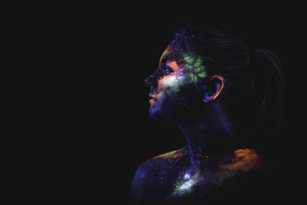 Концептуальный снимок света и блеска флуоресцентных красок лица молодой девушки - Фото, изображение