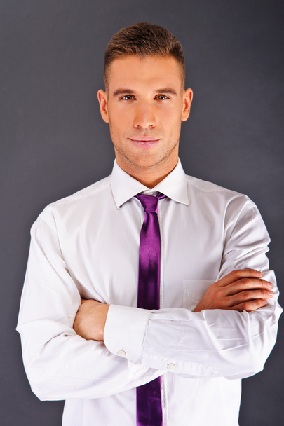 暗い背景上の紫色のネクタイを持つ男 - 写真・画像