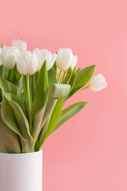 Bouquet of white tulip in vase on millennial pink. - Zdjęcie, obraz