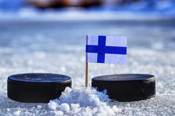 Kürdan iki hokey adam arasında bir Finlandiya bayrağı. Bir Finlandiya olacak Dünya Kupası Grup A. 2019 IIHF Dünya Şampiyonası Slovakya oynarken - Fotoğraf, Görsel