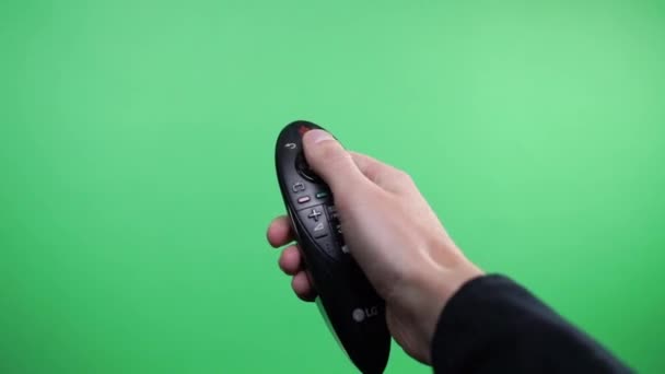 Television Remote Changing Channels On Green Screen. Hand using a remote control over a green screen background - Séquence, vidéo