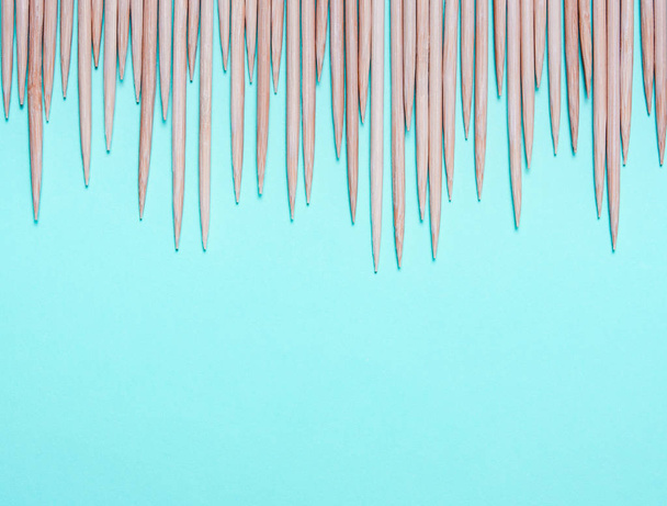 Sharp wooden spikes on a blue background. The concept of pain, discomfort, emotions, hemorrhoids - Foto, imagen