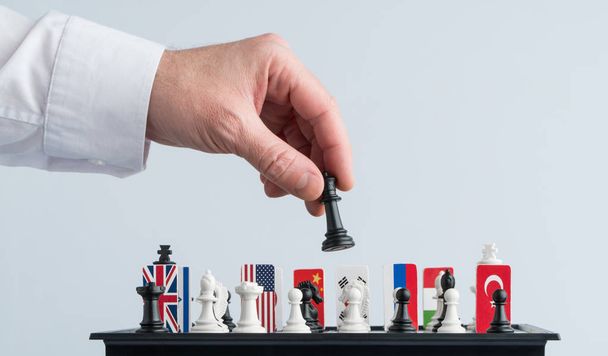 La main d'un politicien déplace une pièce d'échecs. Photo conceptuelle d'un jeu et d'une stratégie politiques
. - Photo, image