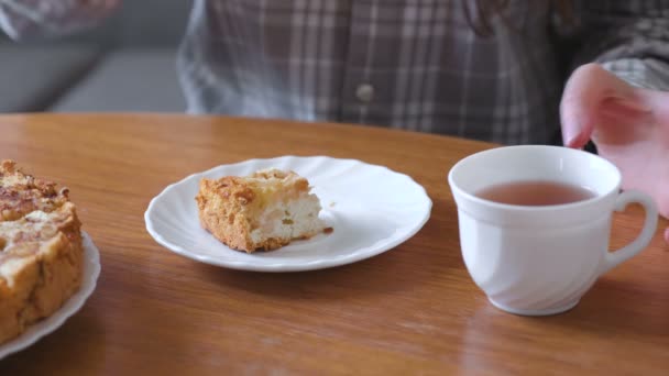 Femme mange de la tarte aux pommes maison et boit un thé. Gros plan des mains
 - Séquence, vidéo