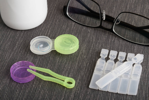 Contact lenses  and artificial tear eye drops with tweezers, case and multipurpose solution - Fotó, kép