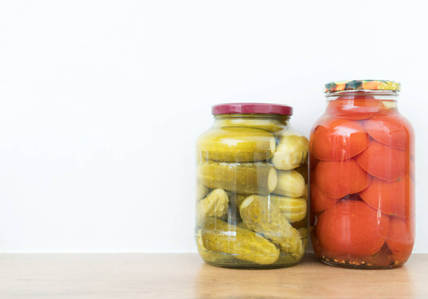 Marinated cucumbers and tomatoes in jars. Space for text. - Photo, Image