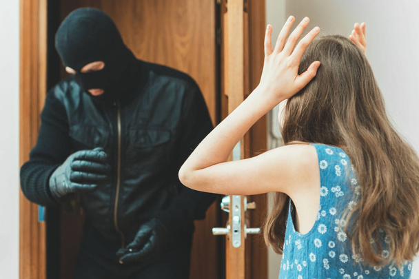 Przestraszony małej dziewczynki i wściekły bandyta wejściu do drzwi. - Zdjęcie, obraz