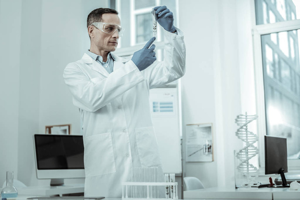 Short-haired scientist wearing special protective uniform in laboratory - Photo, Image