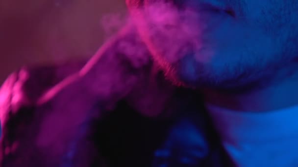 Male with modern e-cigarette blowing smoke at party in night club, alternative - Záběry, video