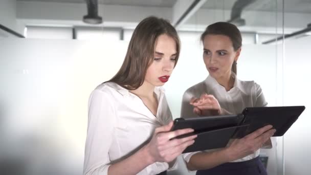 4. Two  pretty business woman  in office with tablet  discuss. Steady shot - Materiał filmowy, wideo