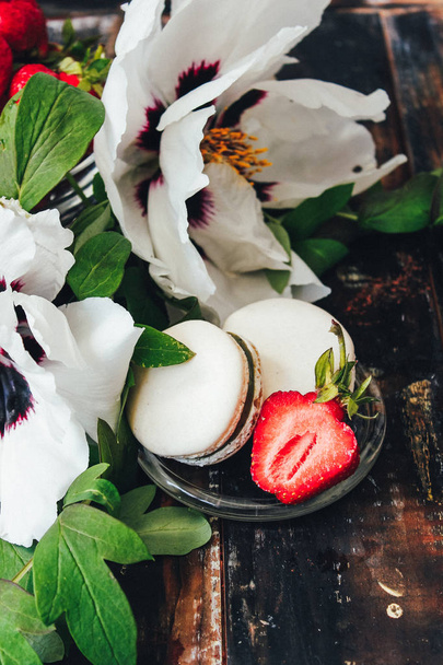 макароны с клубникой и белыми цветами на деревянном фоне
 - Фото, изображение