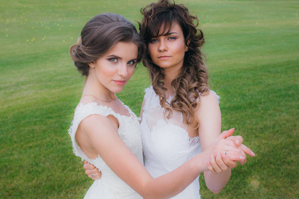 Duas belas noivas dançando no campo verde do clube de golfe
 - Foto, Imagem