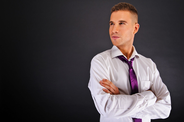 άνθρωπος με μοβ γραβάτα σε σκούρο φόντο - Φωτογραφία, εικόνα