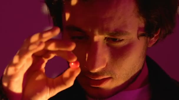 Relaxed man dancing at night club party, taking ecstasy pill, drug addiction - Filmagem, Vídeo
