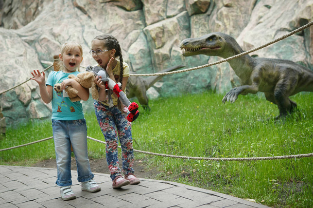 Ρωσία, Σιβηρία - 2016: δύο κορίτσια φοβάται δεινόσαυρος - Φωτογραφία, εικόνα