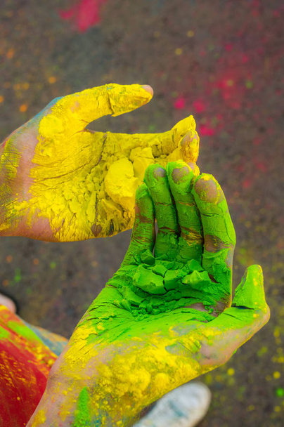 Twee handen met groen en oranje droog hawley verf - Foto, afbeelding