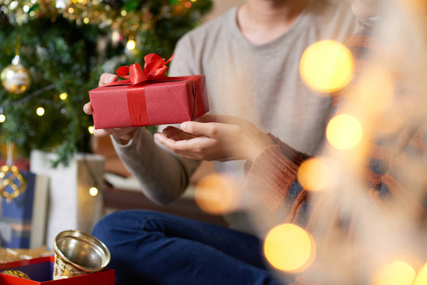 Noel arifesinde, kırpılmış görüntü kız arkadaşına hediye veren erkek - Fotoğraf, Görsel