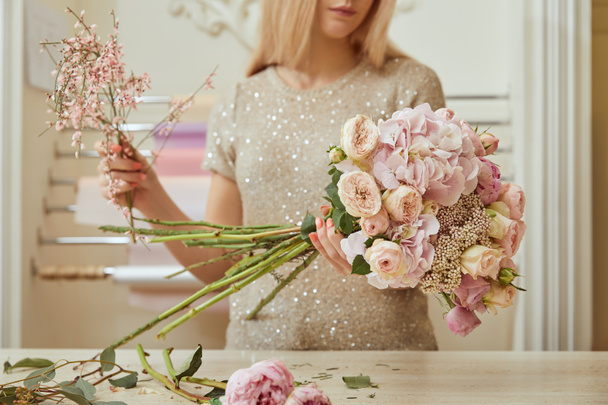 селективная направленность кружевного взгляда флориста, делающего букет из роз и пионов на рабочем месте
 - Фото, изображение