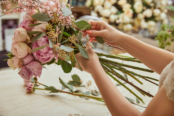  florist making bouquet of roses and peonies at workspace - 写真・画像