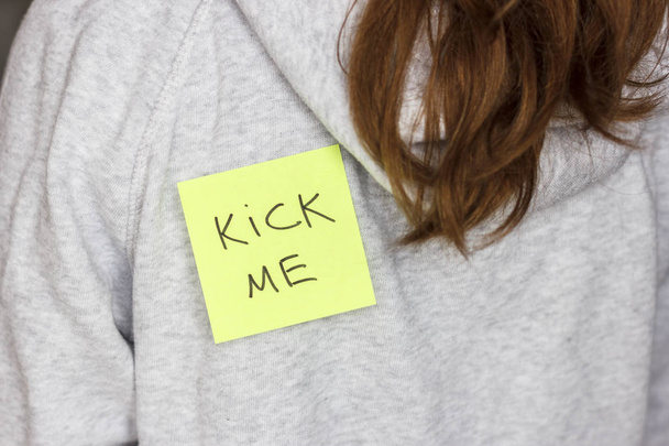 Aufkleber "kick me" auf dem Rücken eines Teenagers. 1 Aprilscherz - Foto, Bild
