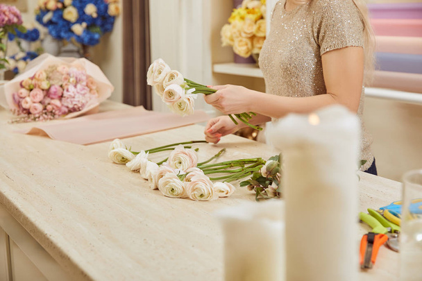 partial view of florist making bouquet of white peonies at flower shop - Foto, Bild