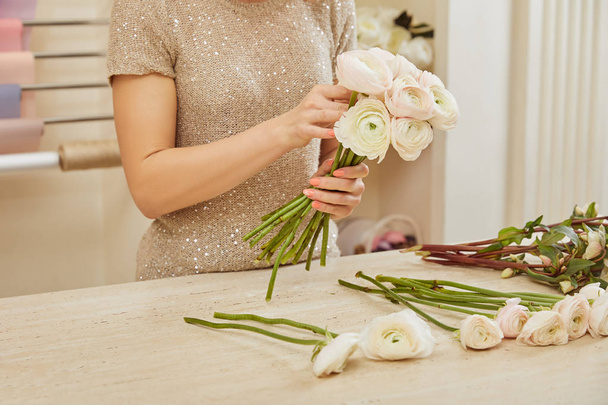 partial view of florist making bouquet of white peonies at workplace - Фото, изображение