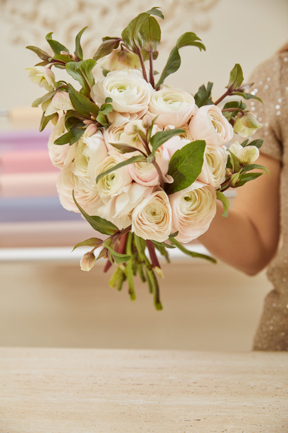 cropped view of florist holding bouquet of white peonies at workspace - Foto, Imagem