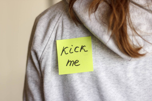 Aufkleber "kick me" auf dem Rücken eines Teenagers. 1 Aprilscherz - Foto, Bild