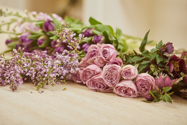  фиолетовые тюльпаны, пионы и сирень на столе в цветочном магазине
 - Фото, изображение