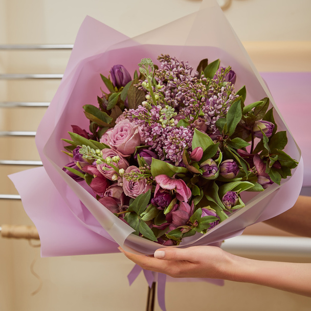 cropped view of florist holding bouquet of tulips, peonies and lilac  - Foto, imagen