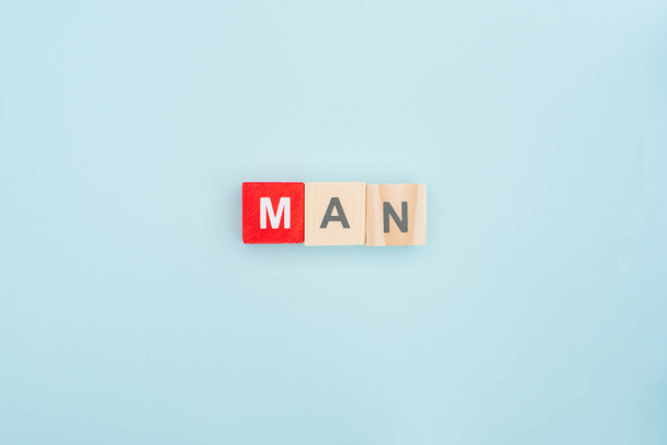 top view of man lettering made of wooden blocks on blue background - Photo, Image