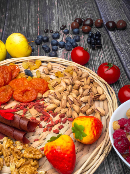 antioxidants, resveratrol food as grape, blueberry, strawberry, tomatoes, raspberry, apples, wild strawberry, cranberry candy, chocolate, dried apricot goji nuts on wooden surface food for brain - Photo, Image