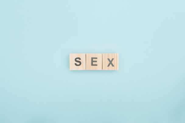 top view of sex lettering made of wooden cubes on blue background - Foto, Bild