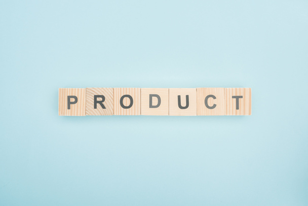 top view of product lettering made of wooden cubes on blue background  - Photo, Image