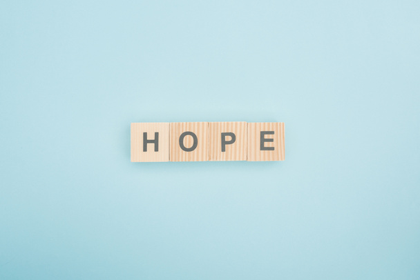 top view of hope lettering made of wooden cubes on blue background  - Foto, imagen