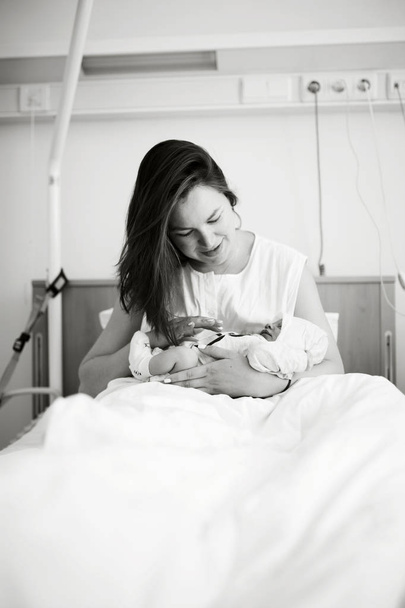 η μητέρα κρατά το μικρό μωρό νεογέννητο, μαύρο και άσπρο - Φωτογραφία, εικόνα