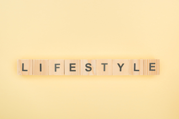 vista superior de letras de estilo de vida hechas de cubos de madera sobre fondo amarillo
 - Foto, imagen